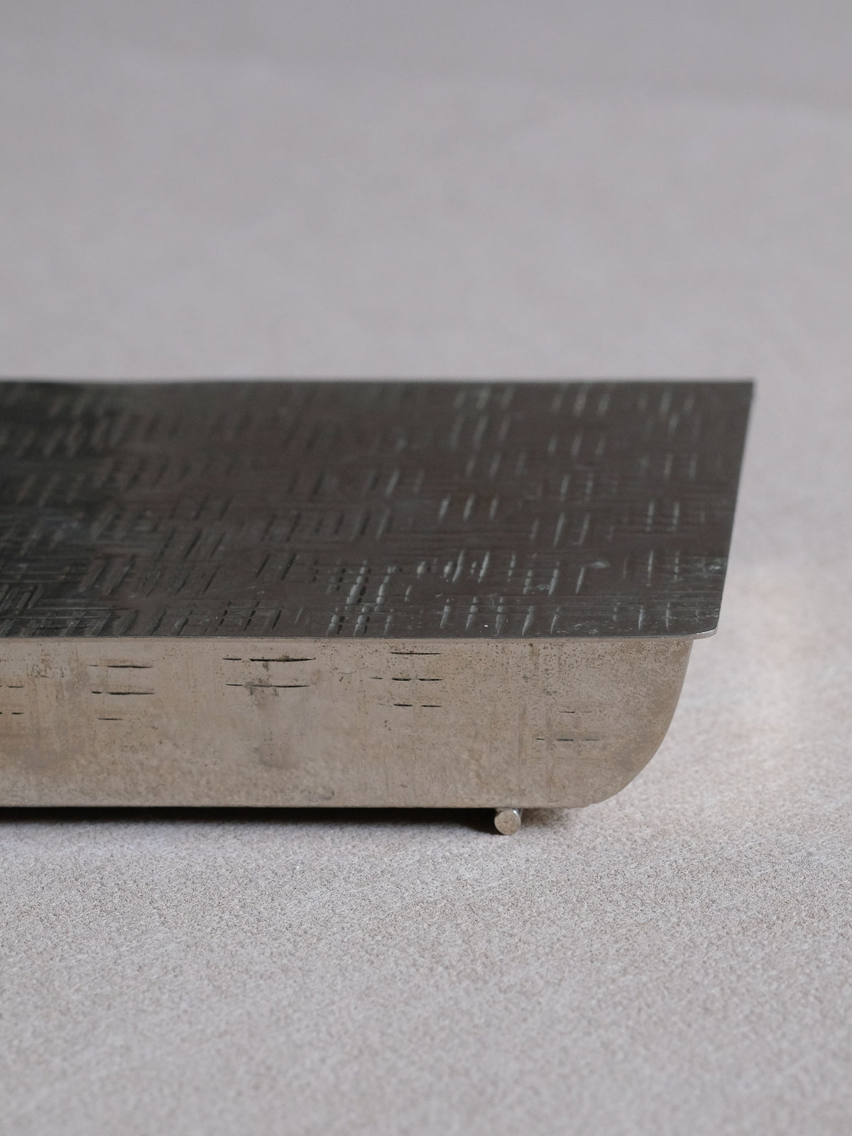 Angled view of the silver-plated Art Deco table matchbox showing its compact architectural profile and geometric decoration.