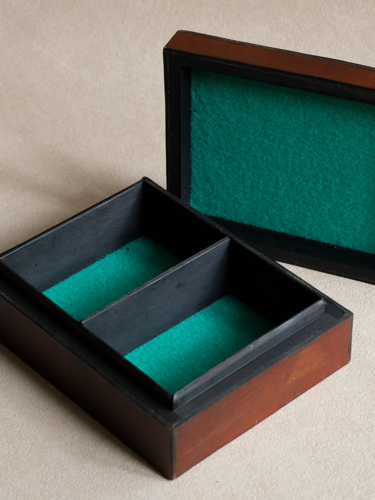 Open vintage Polish leather jewellery box showing the green padded lining and divided interior compartments.