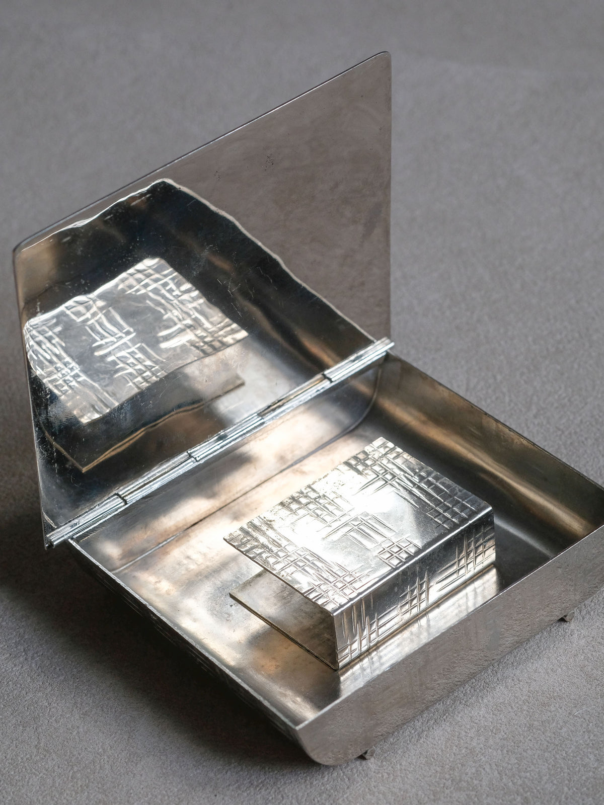 Close detail of the geometric surface pattern on the silver-plated French Art Deco table matchbox.