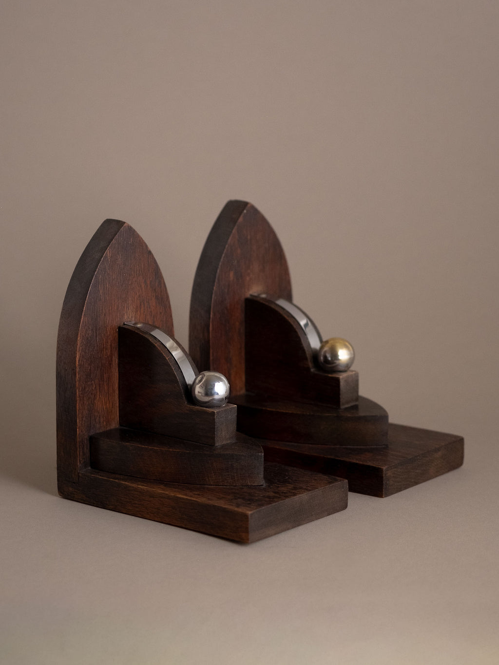 Front view of pair of Dutch Amsterdam School oak bookends, interwar period, with curved nickel-plated brass bands and sphere finials.