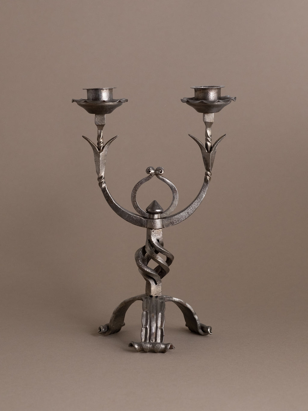 Full frontal view of hand-forged wrought iron two-arm candleholder, 1960s Europe.