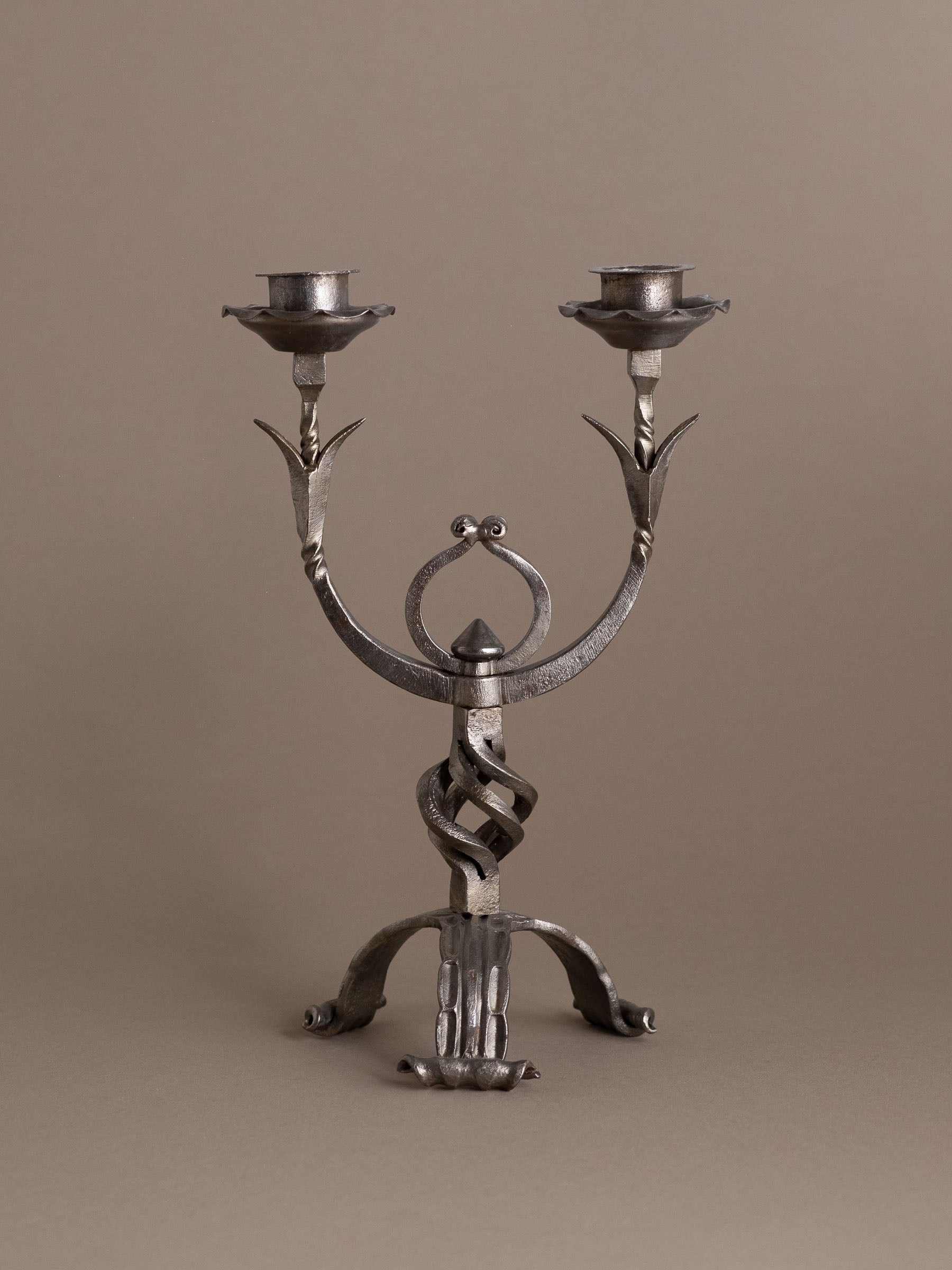 Full frontal view of hand-forged wrought iron two-arm candleholder, 1960s Europe.