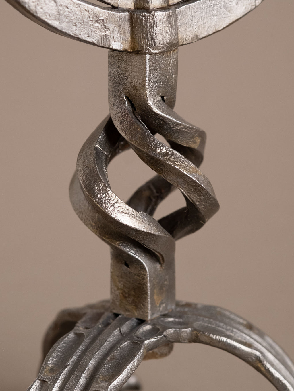 Twisted central shaft and forged joinery on two-arm wrought iron candleholder.