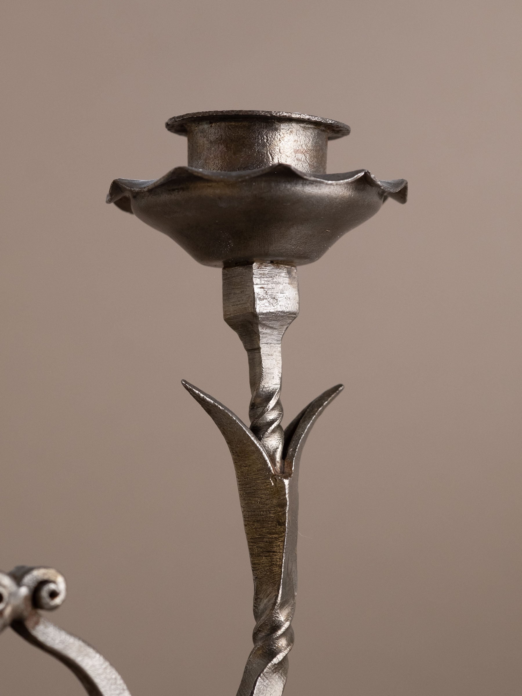 Detail of upper candle cup and scalloped drip pan on wrought iron candleholder.