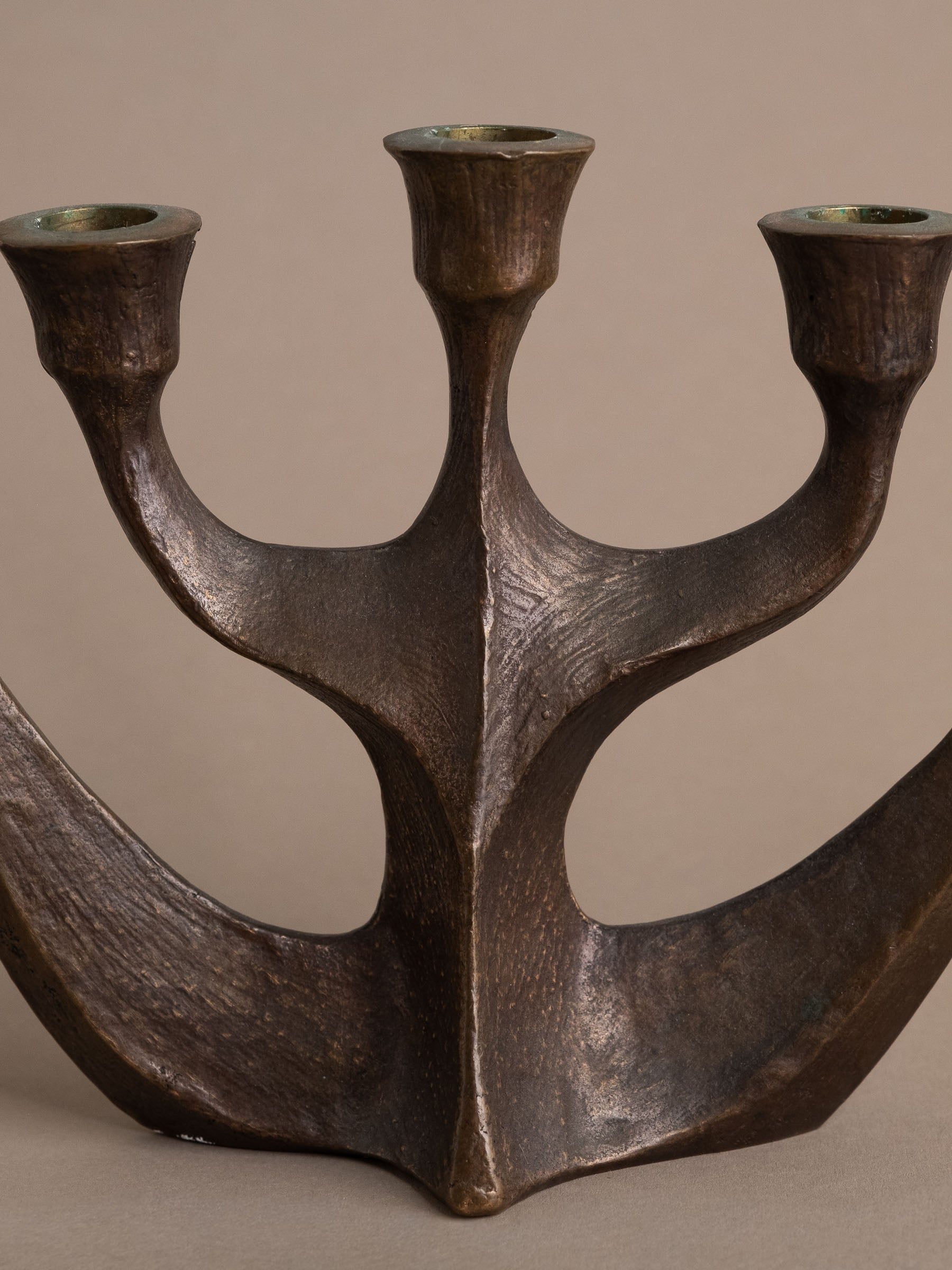 Front detail of central spine and branching arms on Brutalist bronze candleholder.