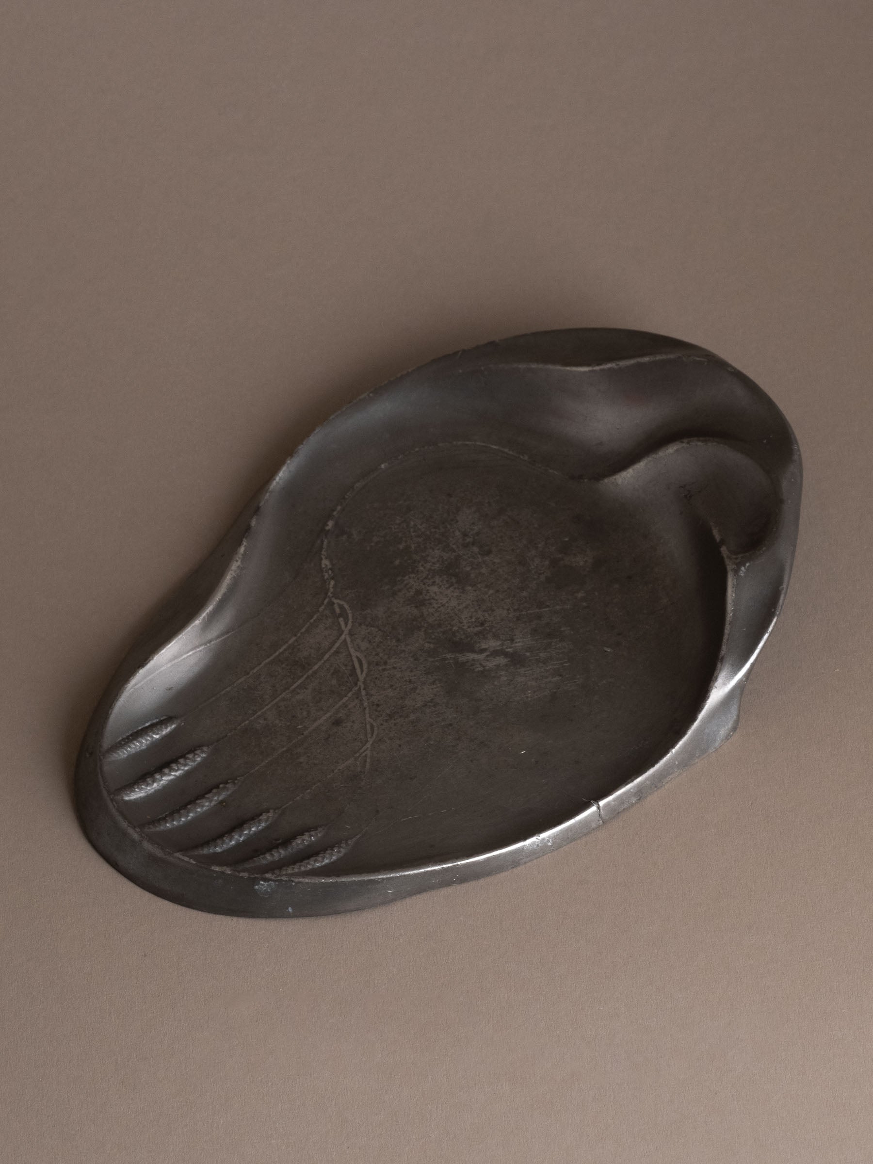 Top view of Kayserzinn Model 4411 art pewter plate showing asymmetrical rim and wheat motif in low relief.