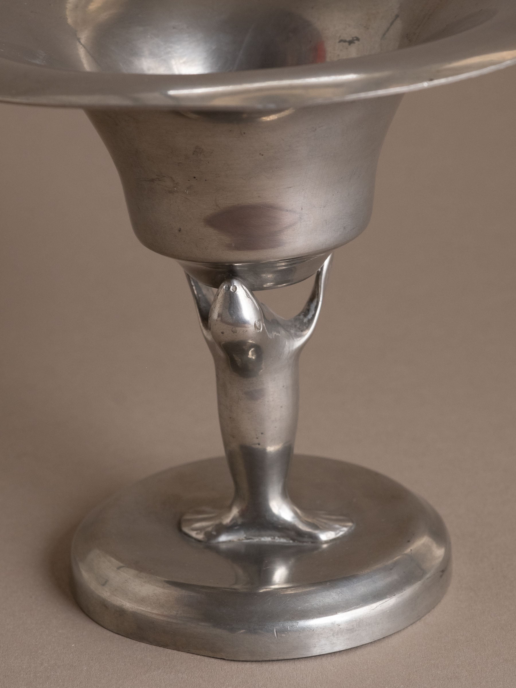 Close-up of the stylised sea lion figure supporting the pewter bowl, Dahlströms Tenn, Sweden.