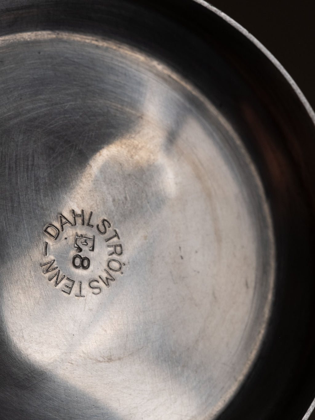 Close-up of Dahlströms Tenn maker’s mark stamped inside the pewter pedestal bowl.