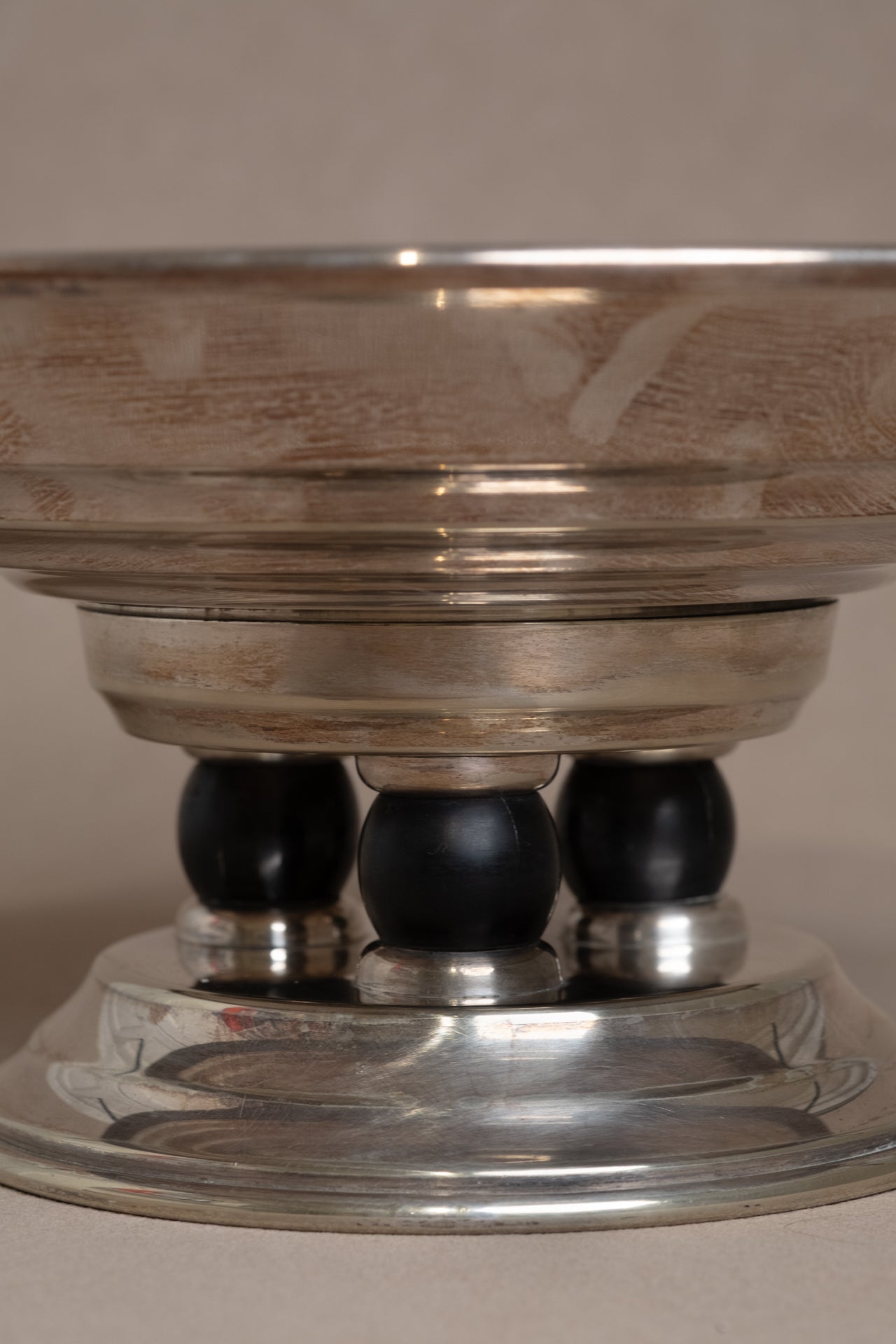 Three dark spherical supports beneath the Art Deco EPNS silver pedestal tazza bowl.