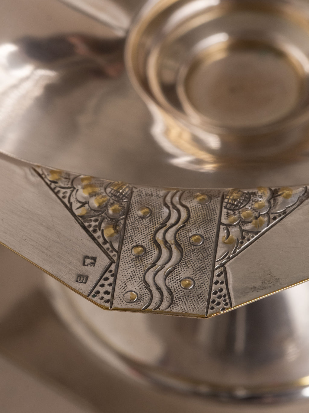 Close-up of the rim panel with engraved decoration and a small square punch reading 10.