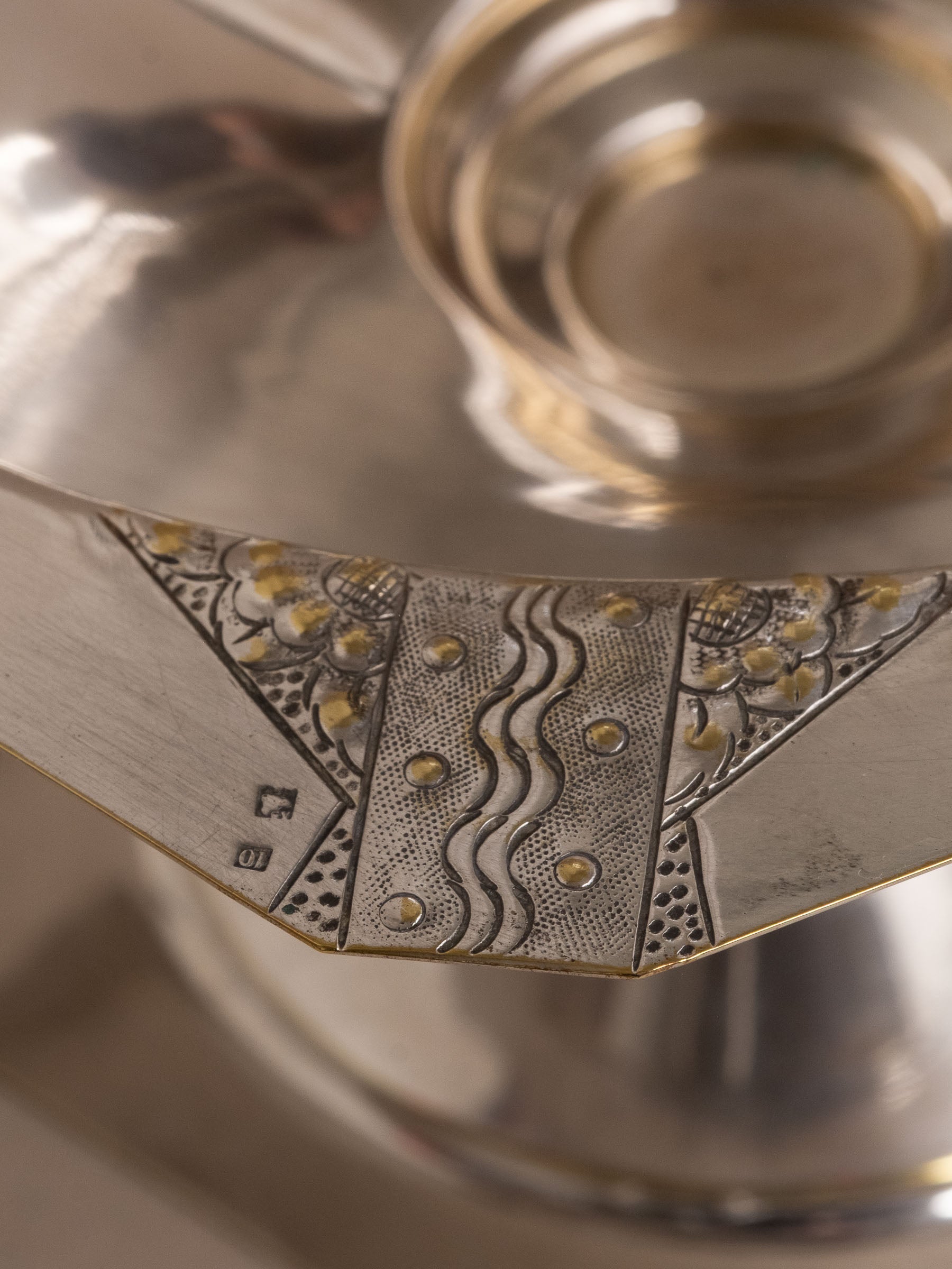 Close-up of the rim panel with engraved decoration and a small square punch reading 10.