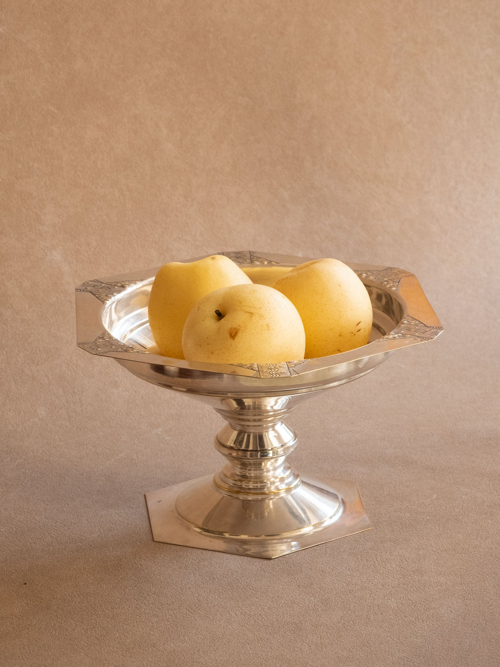 Art Deco silver-plated pedestal bowl with hexagonal rim, styled with three pears in warm natural light.