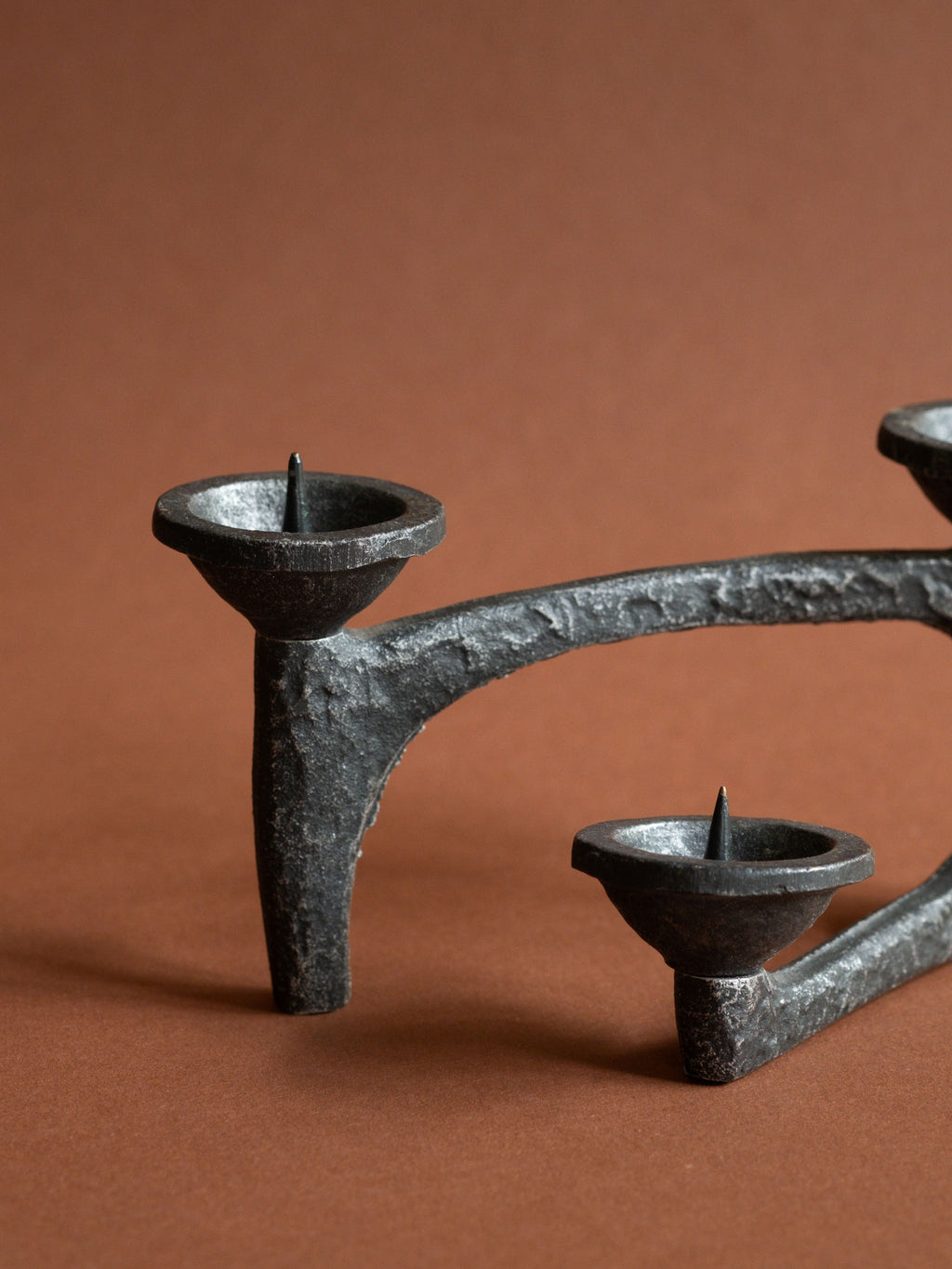 Close-up of the rough textured cast iron surface, pricket bowls and open negative space.