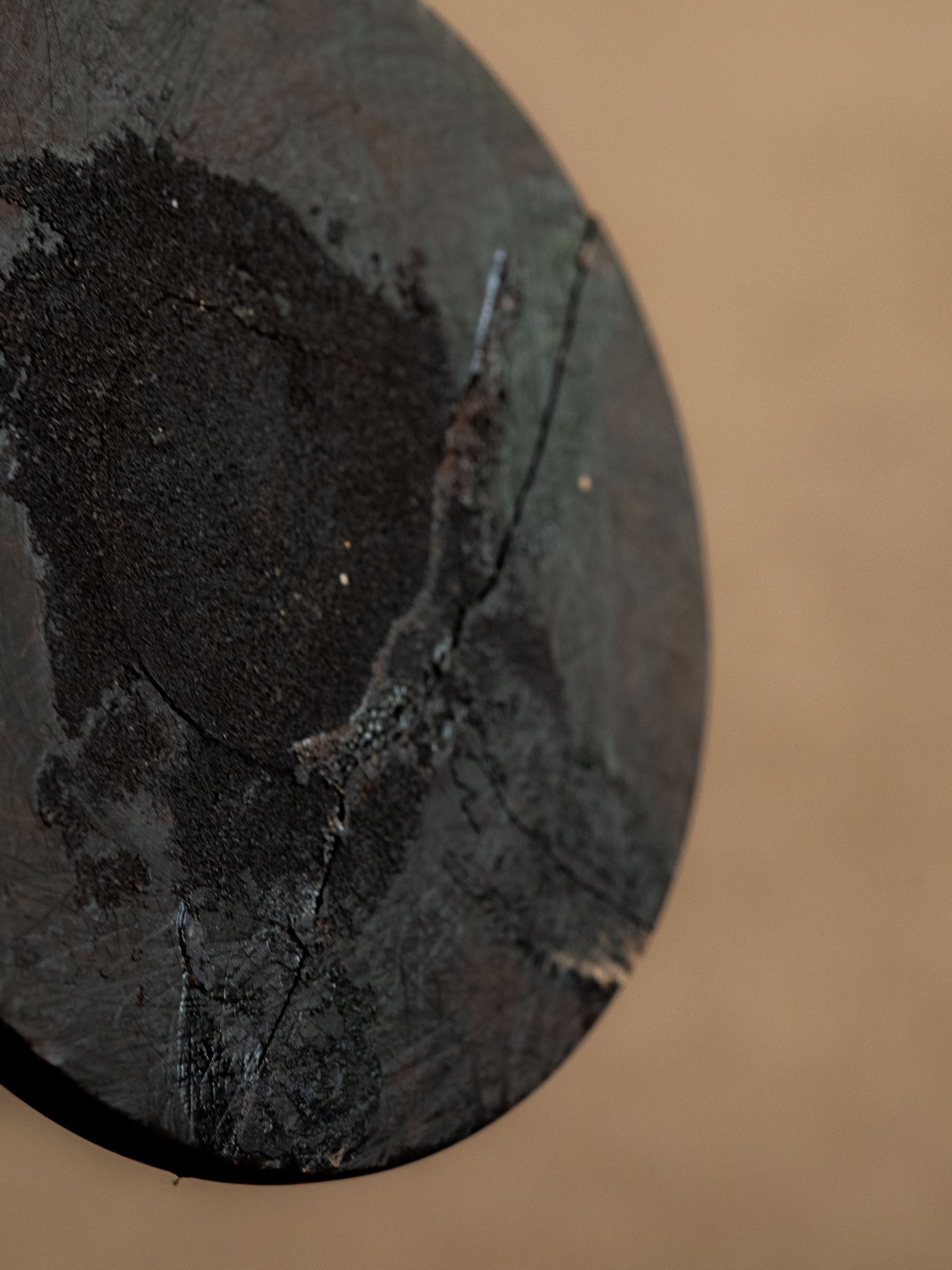 Underside of one ebony candleholder showing the old stable repair and base surface.