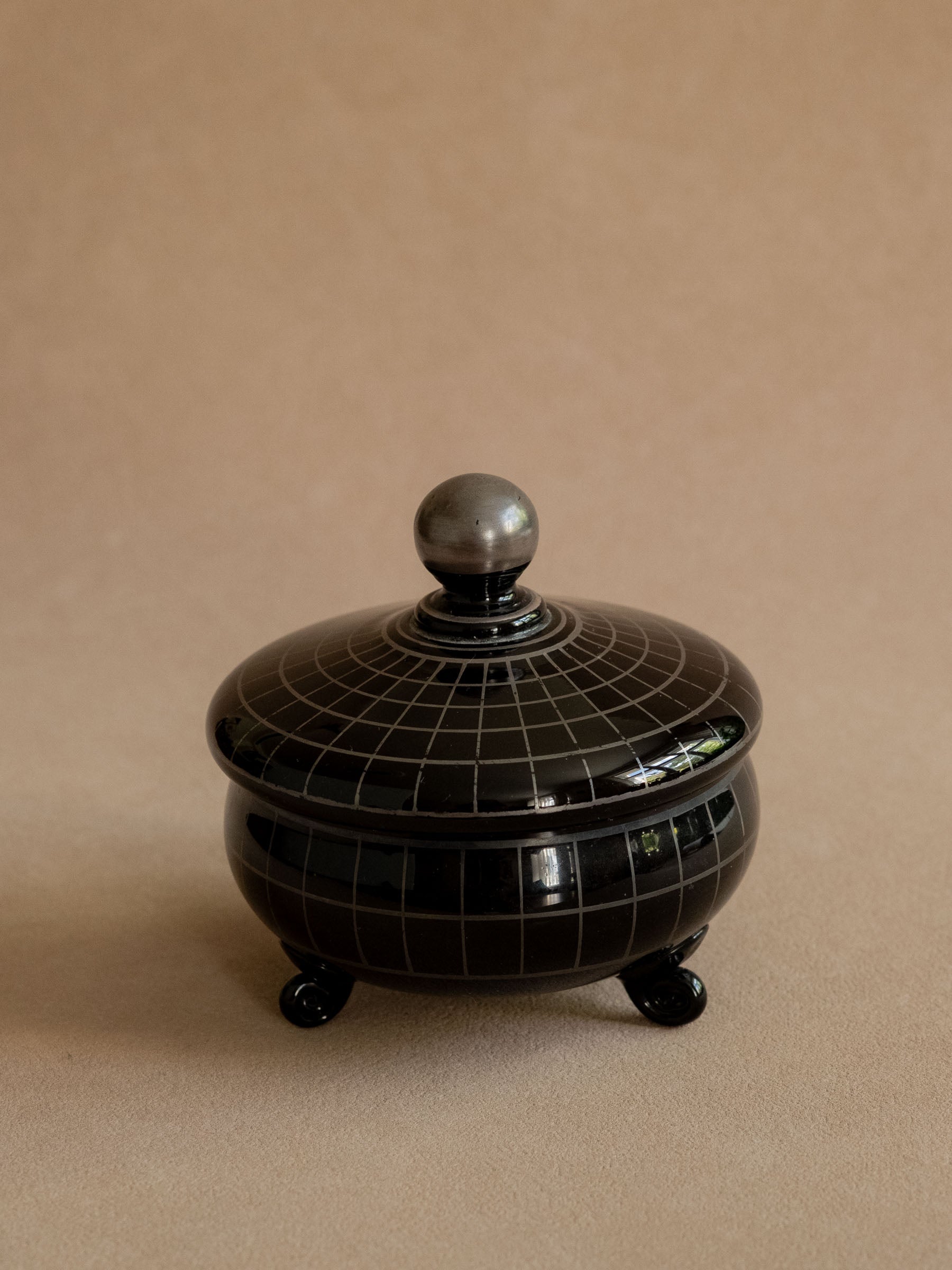 Black Hyalith glass Art Deco box from France shown closed, with silver-coloured grid decoration and ball finial.