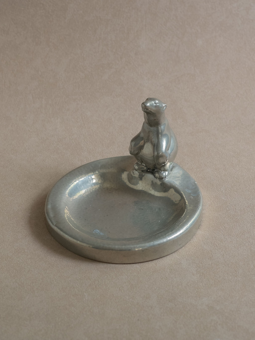 Front view of a pewter polar bear figural dish on a neutral background, showing the low bowl form and upright animal figure.

