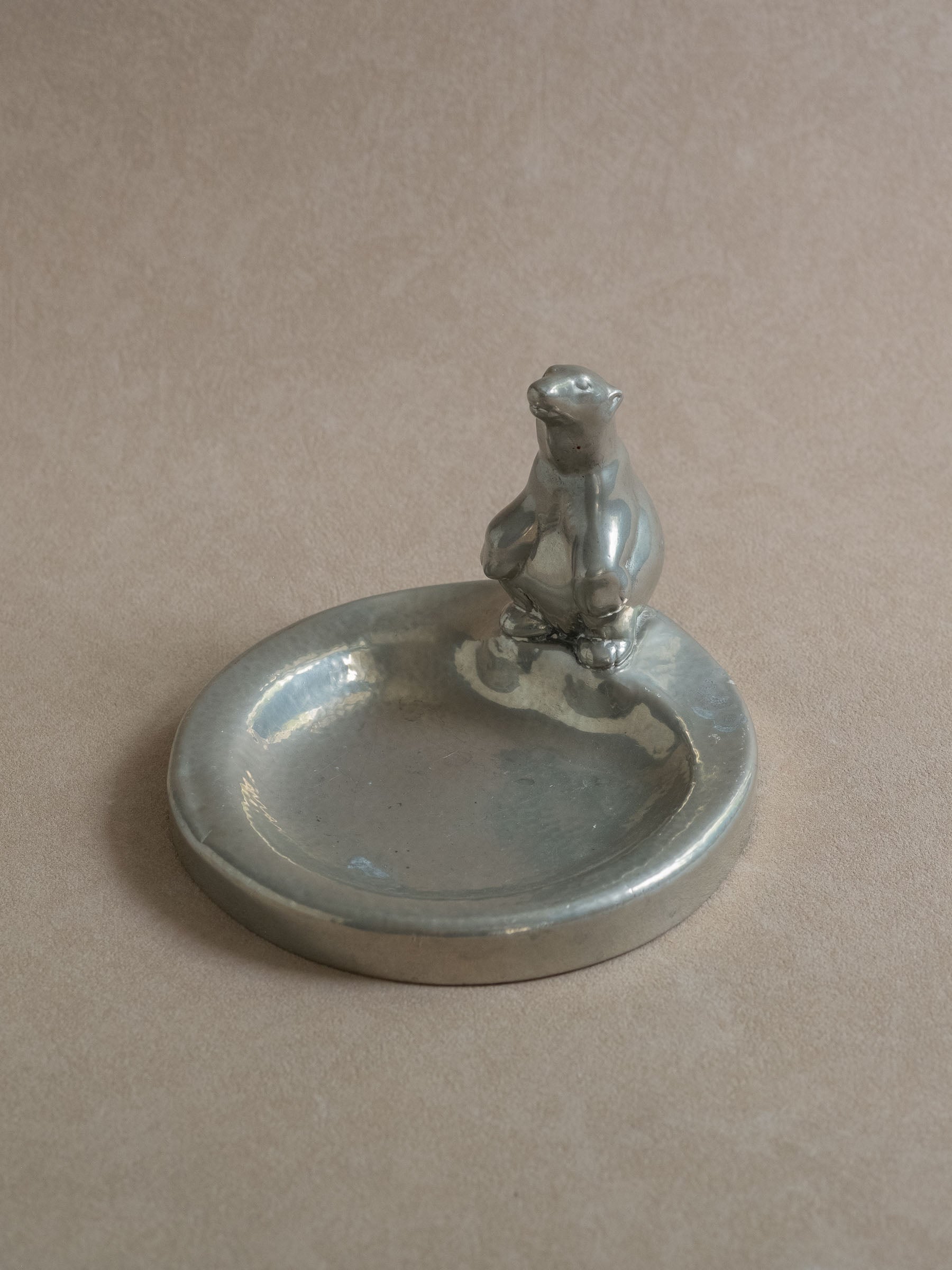 Front view of a pewter polar bear figural dish on a neutral background, showing the low bowl form and upright animal figure.
