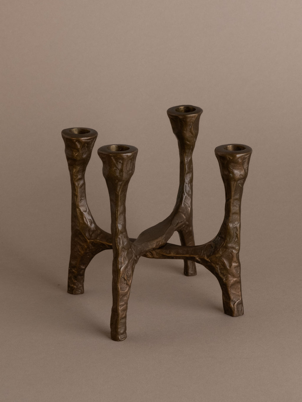 Brutalist four-arm bronze candleholder, Germany, 1970s, full view on neutral background.