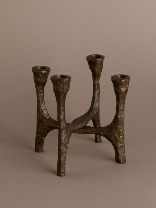 Brutalist four-arm bronze candleholder, Germany, 1970s, full view on neutral background.