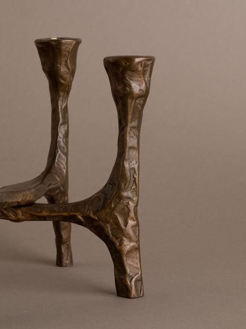 Side view of Brutalist bronze four-arm candleholder showing sculptural cross-braced form, Germany, 1970s.
