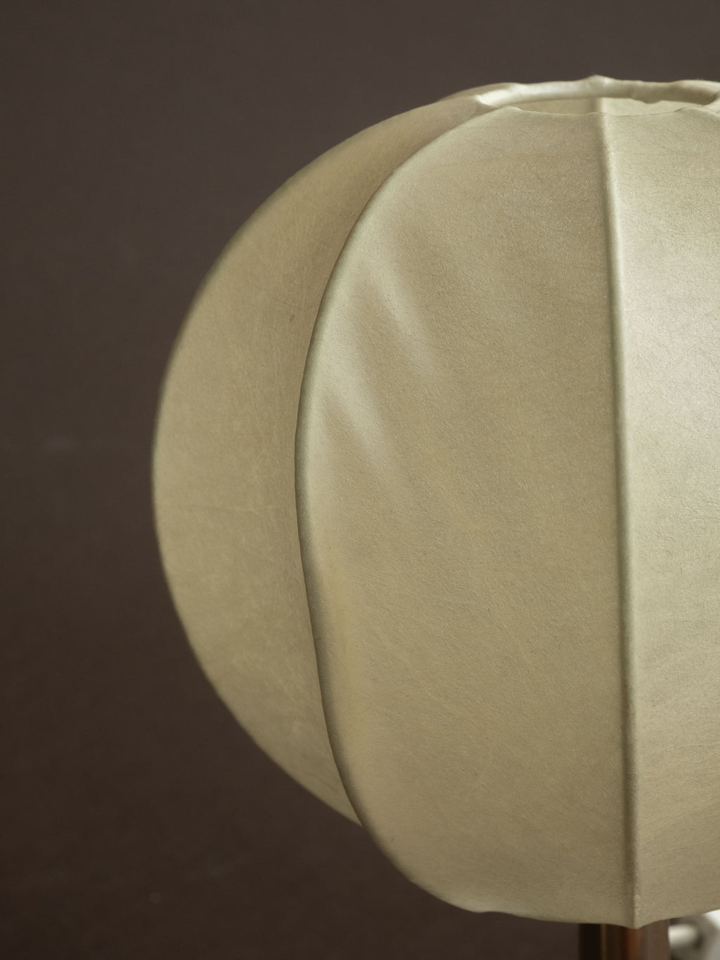 Close detail of a Goldkant Salbo cocoon table lamp shade, showing the off-white sprayed-resin surface and ribbed panel structure.
