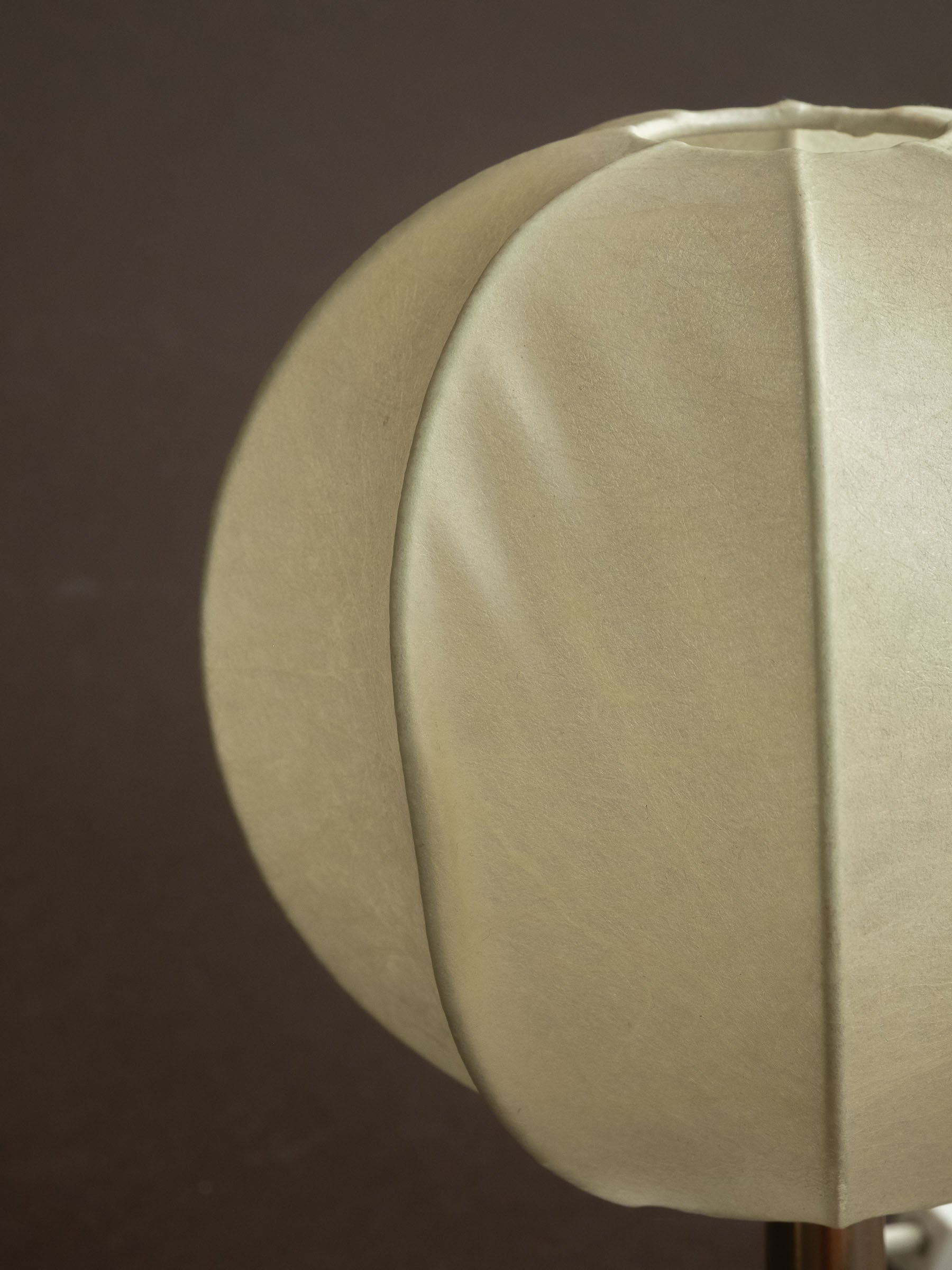 Close detail of a Goldkant Salbo cocoon table lamp shade, showing the off-white sprayed-resin surface and ribbed panel structure.
