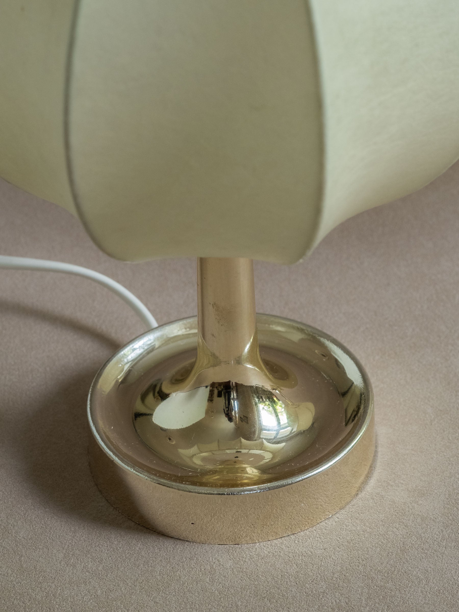 Close side view of two Goldkant Salbo cocoon table lamps showing the off-white ribbed shades and reflective bases.
