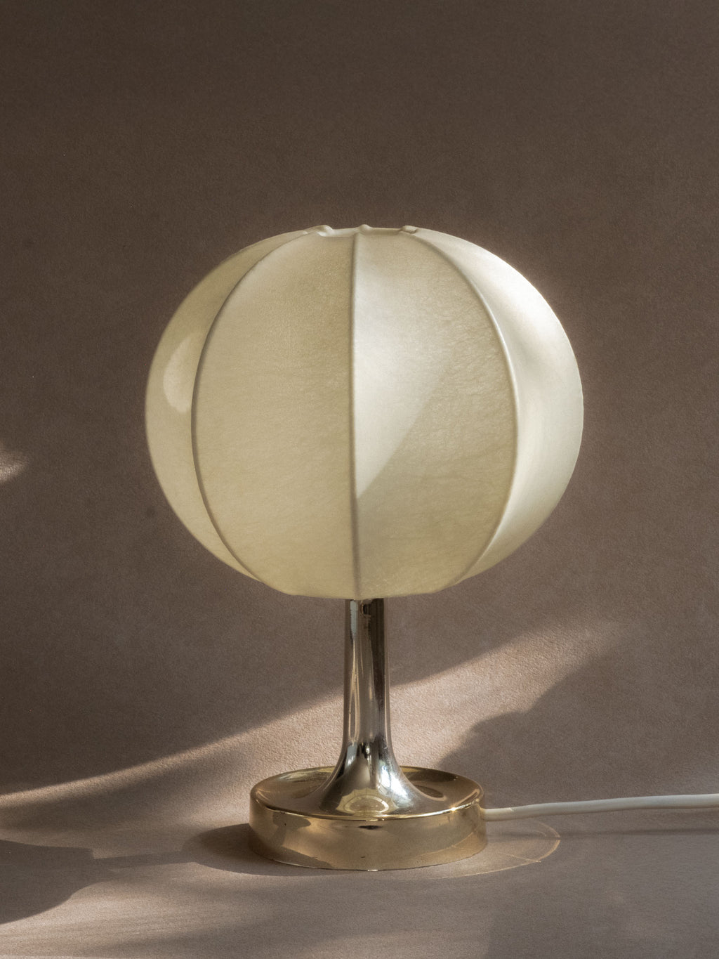 Angled view of a pair of Goldkant Salbo cocoon table lamps showing ribbed shades, slim stems, and chrome-effect circular bases.
