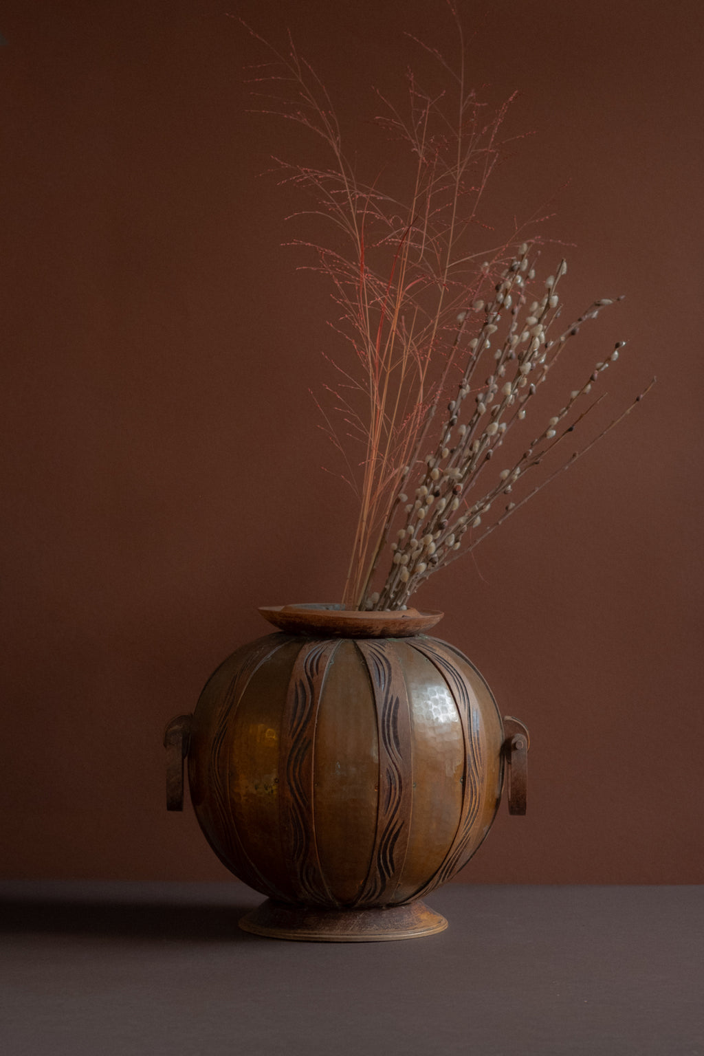 Art Nouveau copper and carved wood vase attributed to Gustave Serrurier-Bovy, Belgium, circa 1900, styled with dried branches on dark surface.
