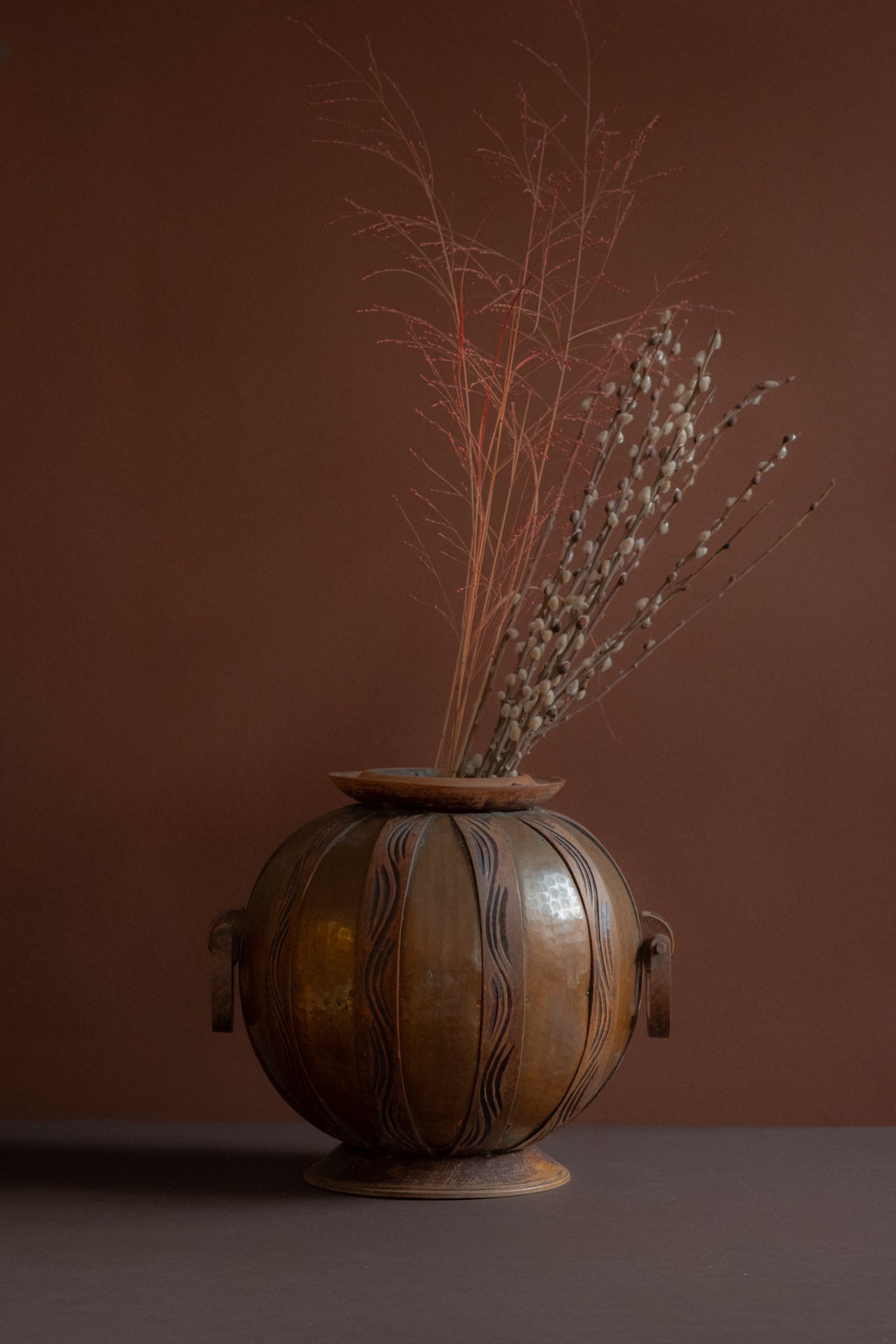 Art Nouveau copper and carved wood vase attributed to Gustave Serrurier-Bovy, Belgium, circa 1900, styled with dried branches on dark surface.