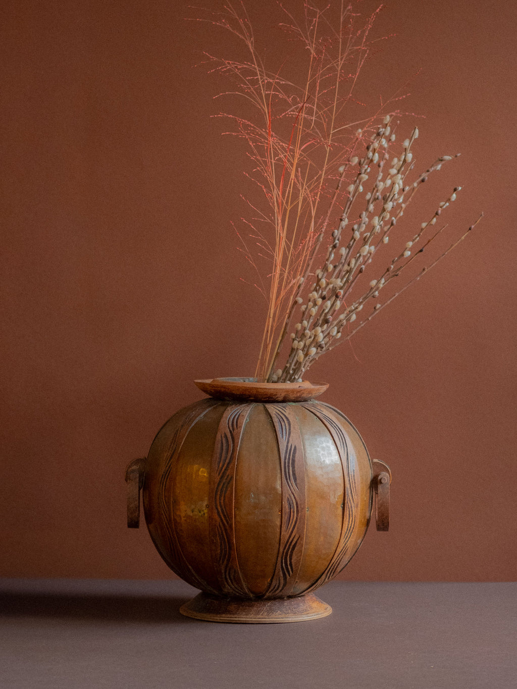 Art Nouveau copper and carved wood vase attributed to Gustave Serrurier-Bovy, Belgium, circa 1900, styled with dried branches on dark surface.