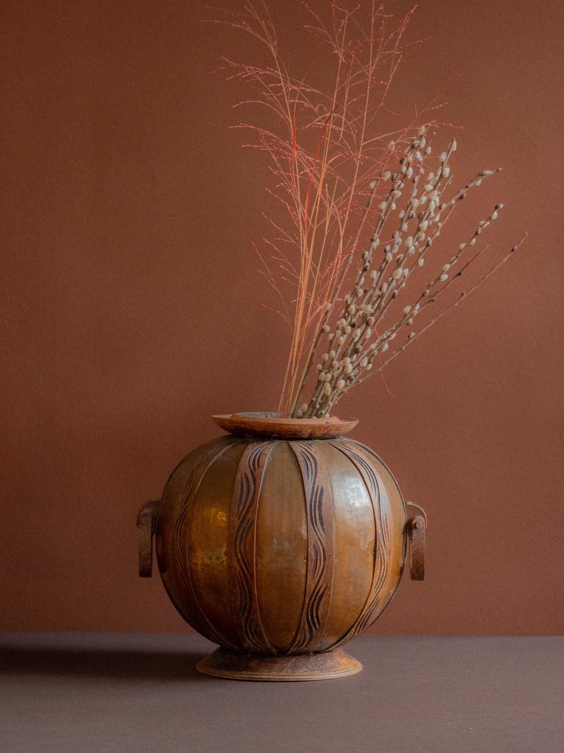Art Nouveau copper and carved wood vase attributed to Gustave Serrurier-Bovy, Belgium, circa 1900, styled with dried branches on dark surface.