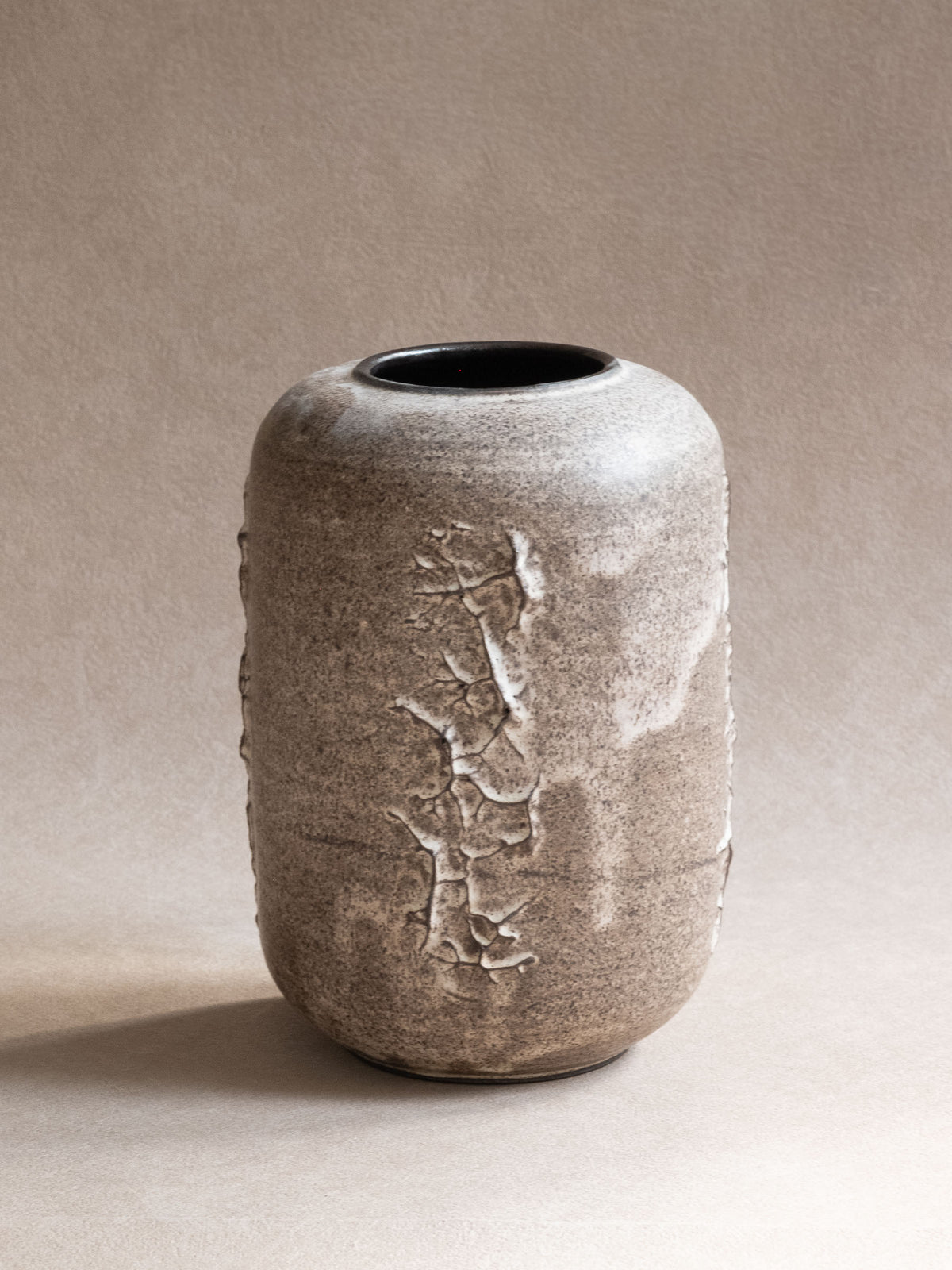 Heiner Hans Körting ceramic vase with rounded grey body and raised white relief decoration.