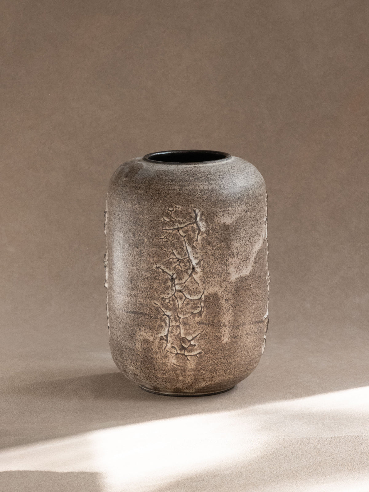 Angled view of the Körting vase showing the dark glazed neck and sculptural relief surface.