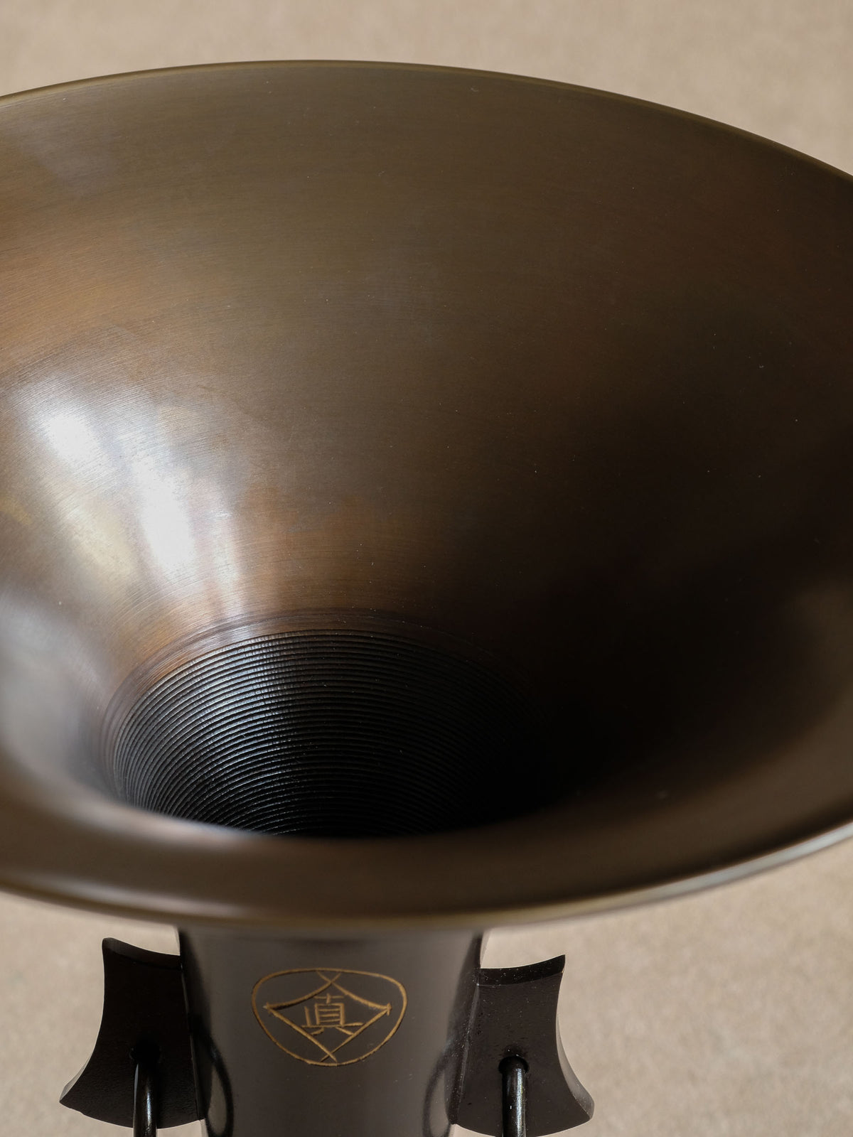 Three-quarter view of the dark bronze Zuishō vase showing its tapering body and wide rim.