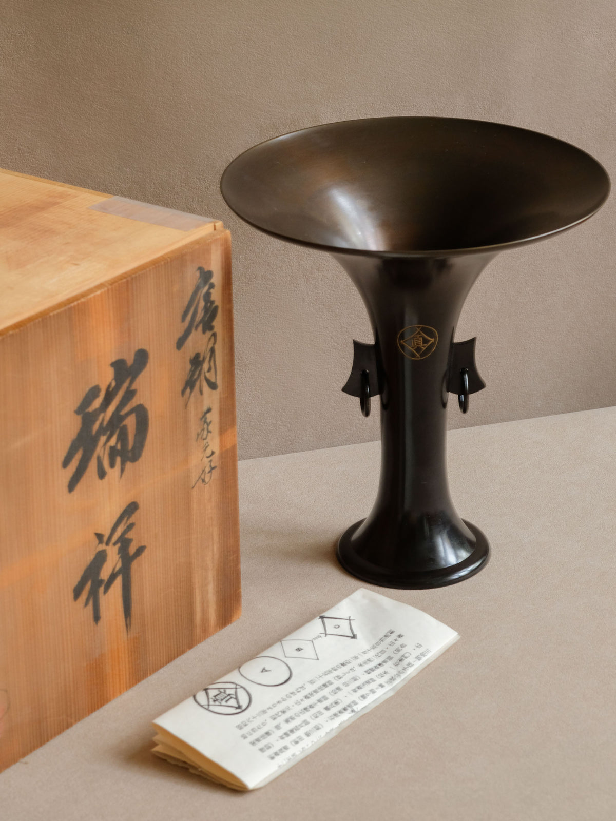 Close photograph of the sweeping lip and fine finished edge of the Zuishō bronze vase.