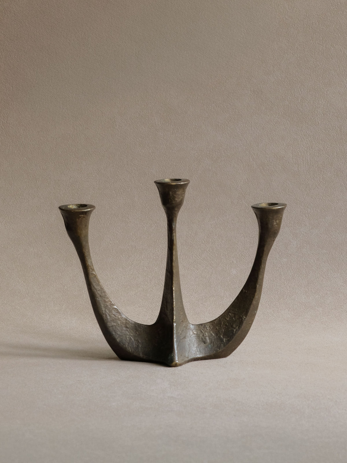 Horst Dalbeck three-arm bronze candleholder with rising sculptural stems and warm aged patina.