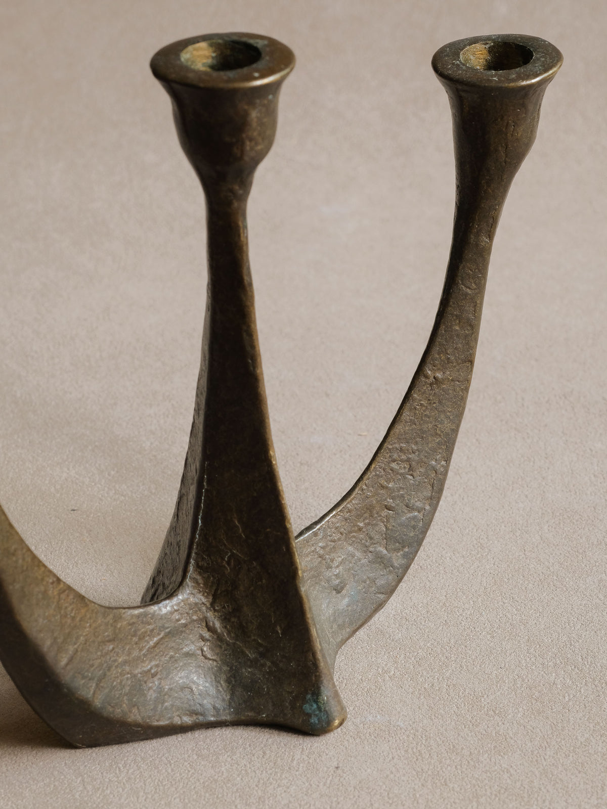 Angled view of the Horst Dalbeck bronze candleholder showing the three flared candle cups.