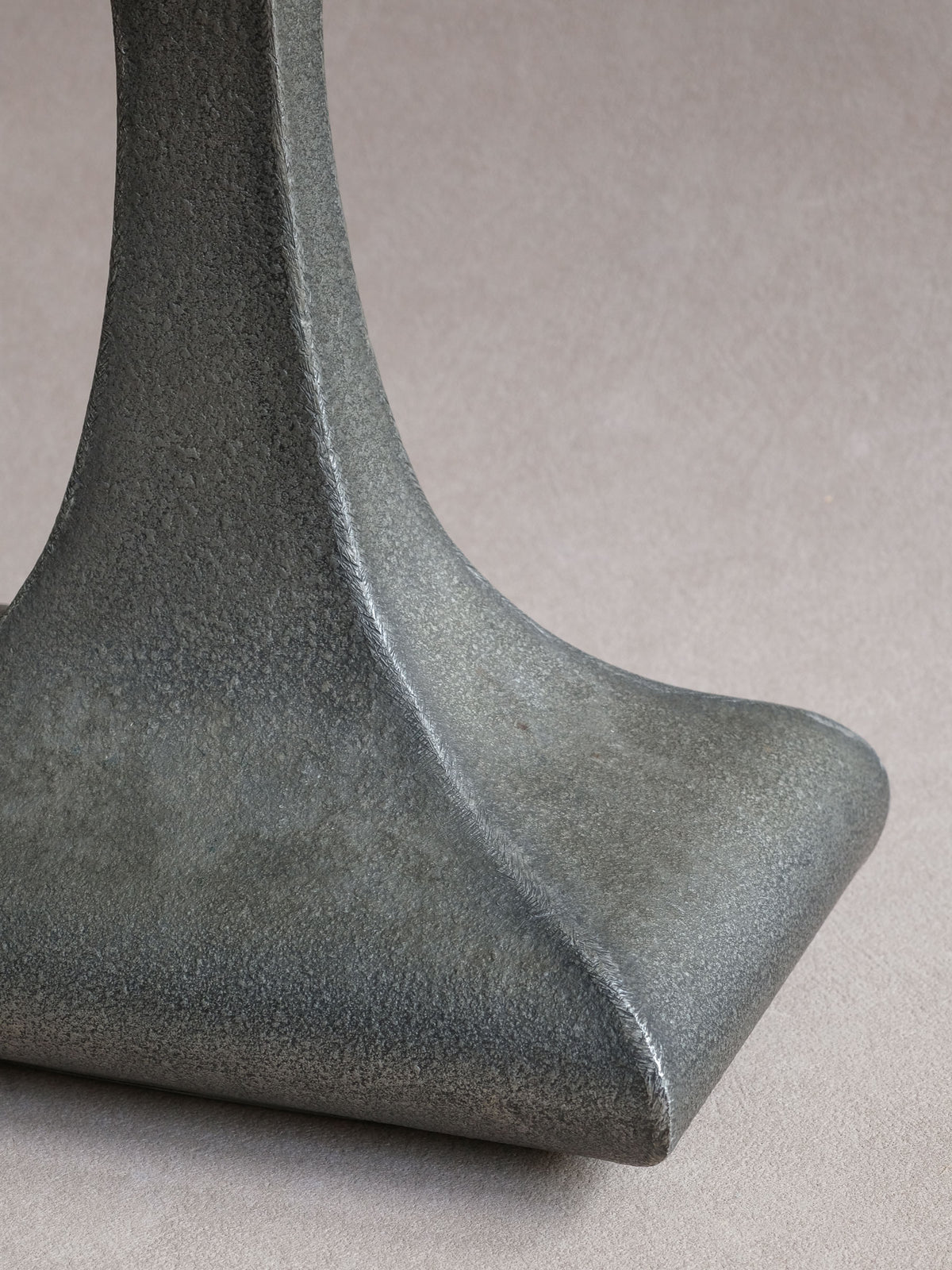 Close-up of the angular lower corner and finely textured pewter surface.