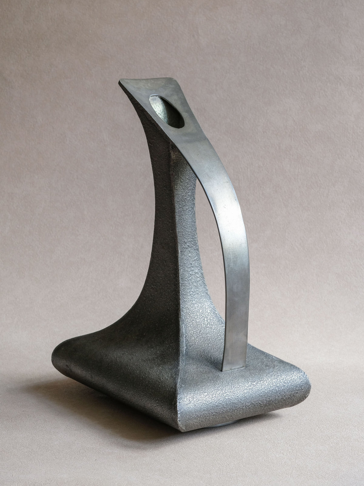 Rear full view of large Italian pewter sculptural vessel showing sweeping handle and tapered neck.