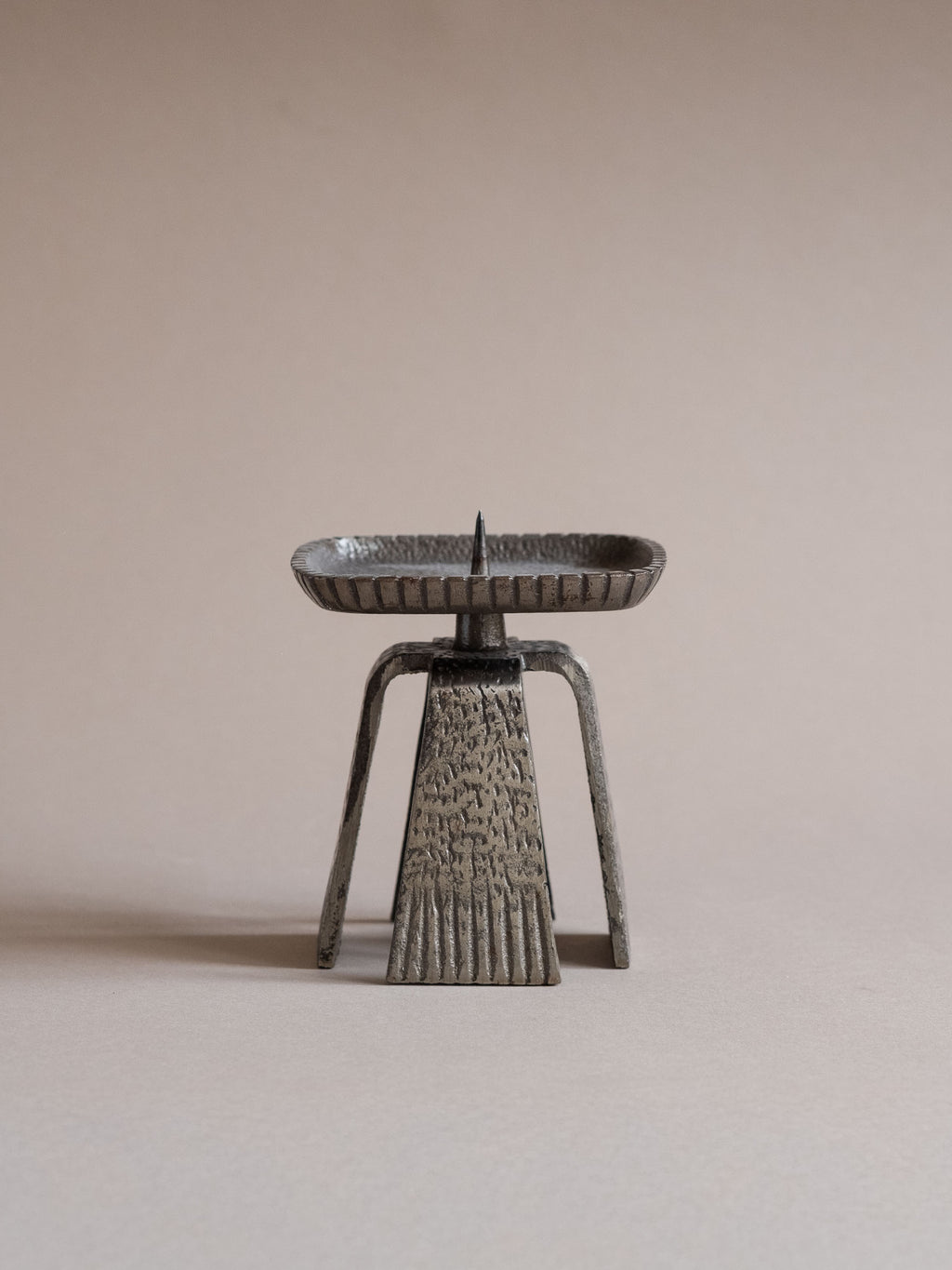 Japanese cast iron pricket candle holder with square tray and four tapered legs, shown front-facing against a neutral background.