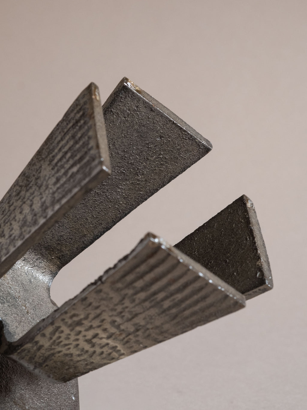Close view of the underside of the cast iron candle holder showing the tapered legs and textured surface finish.