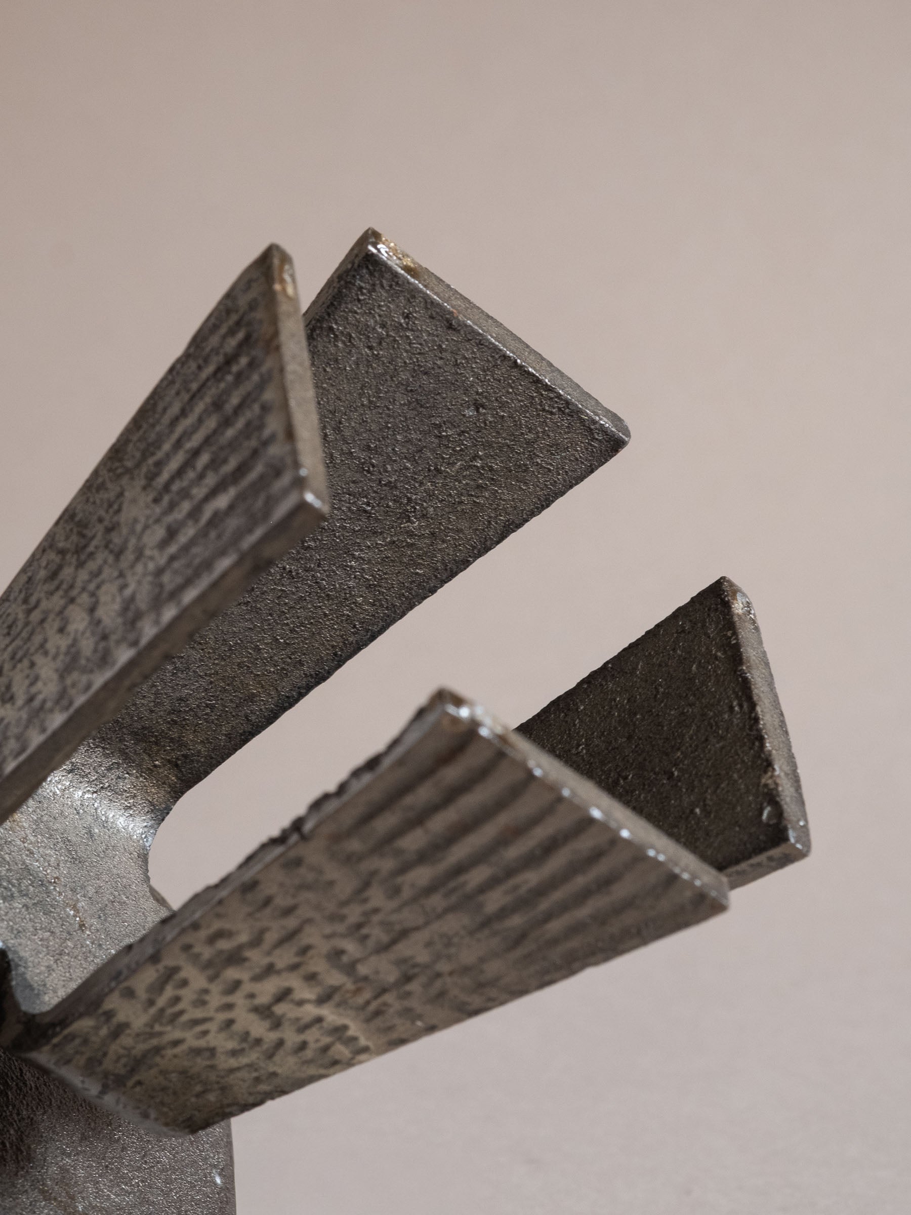 Close view of the underside of the cast iron candle holder showing the tapered legs and textured surface finish.