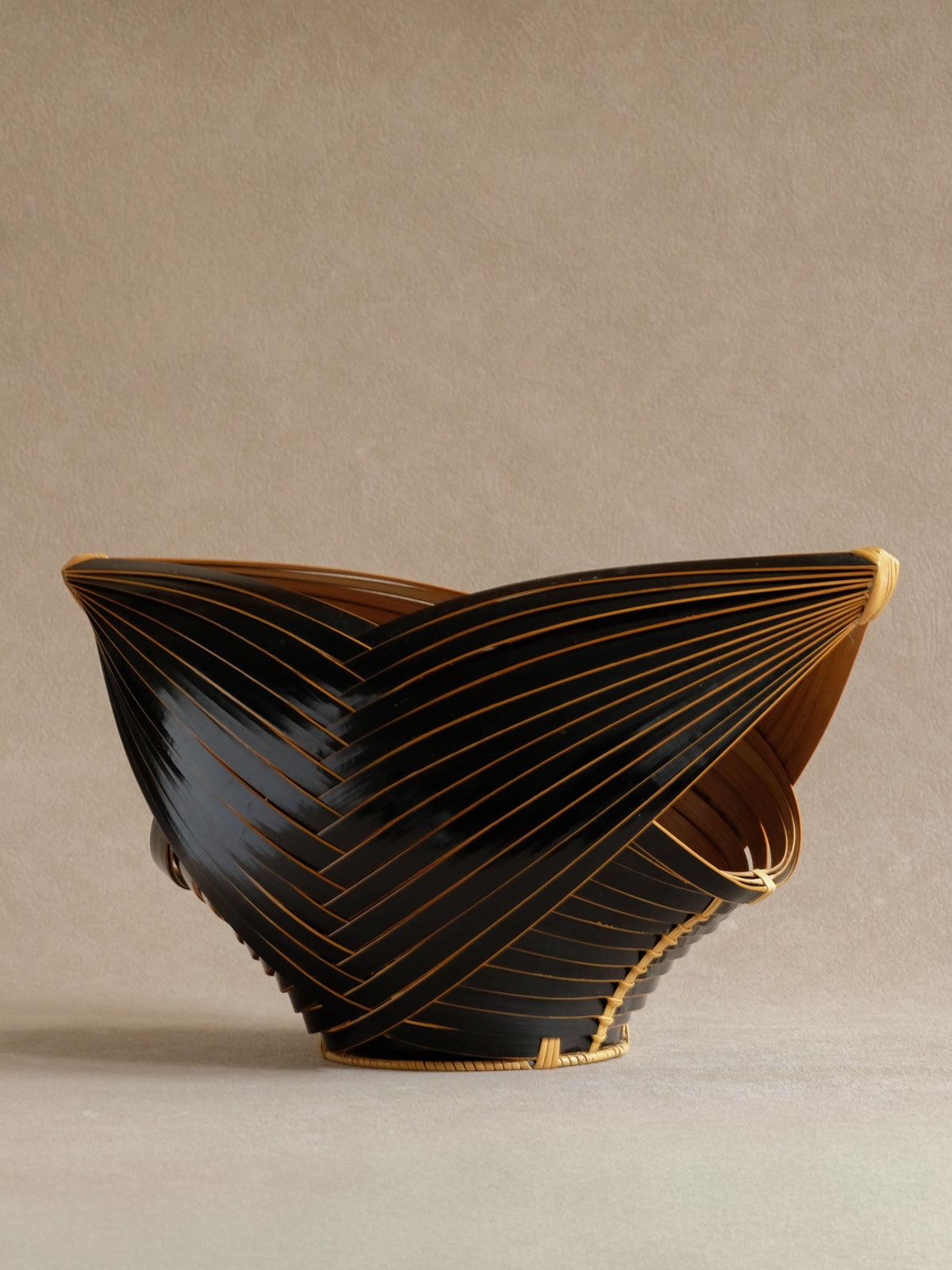 Alternate angle of dark bamboo basket with fine contrasting natural lines.