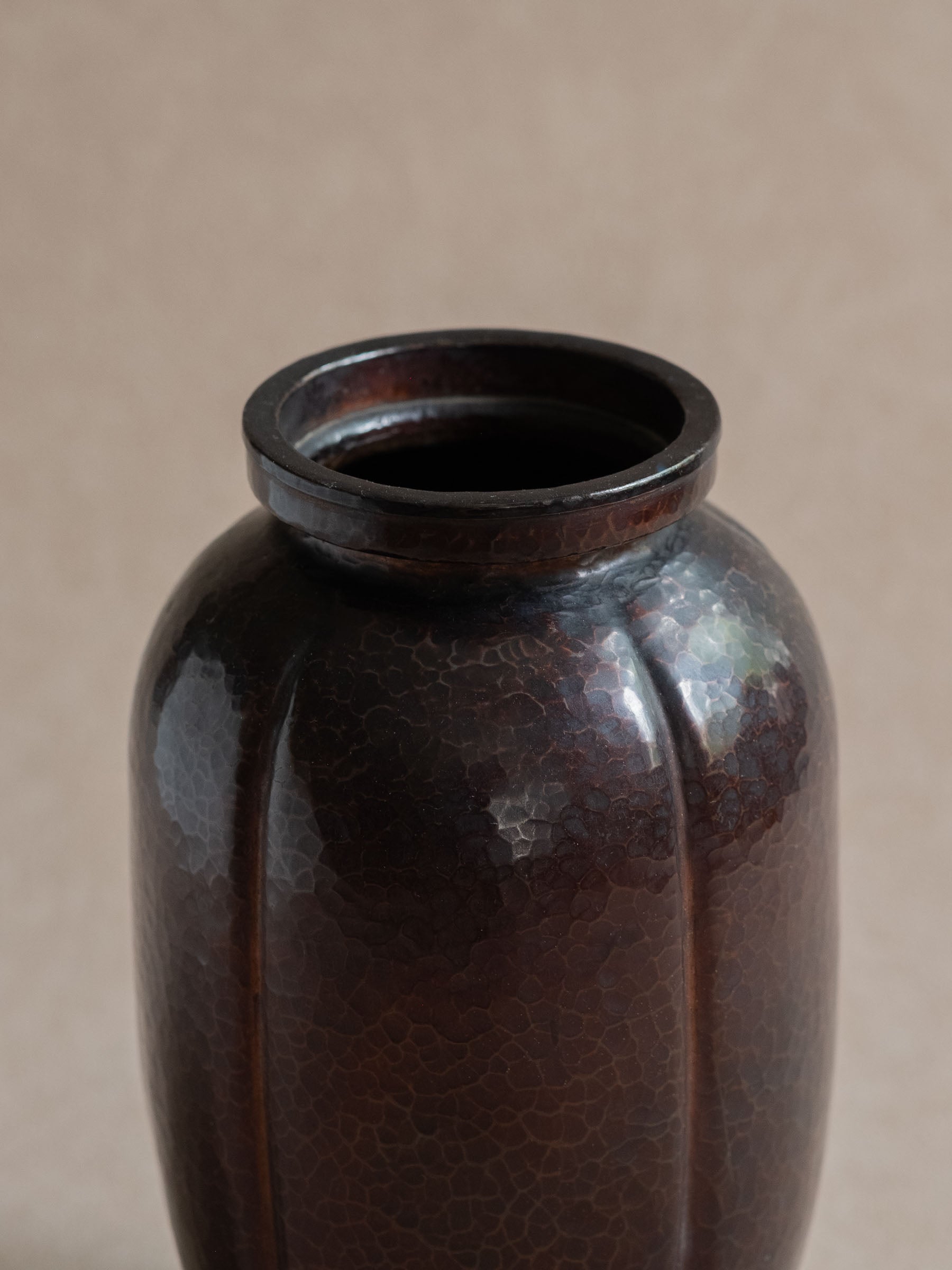 Upper view of Japanese Dochu hand-hammered copper vase showing raised circular rim and dark brown surface.
