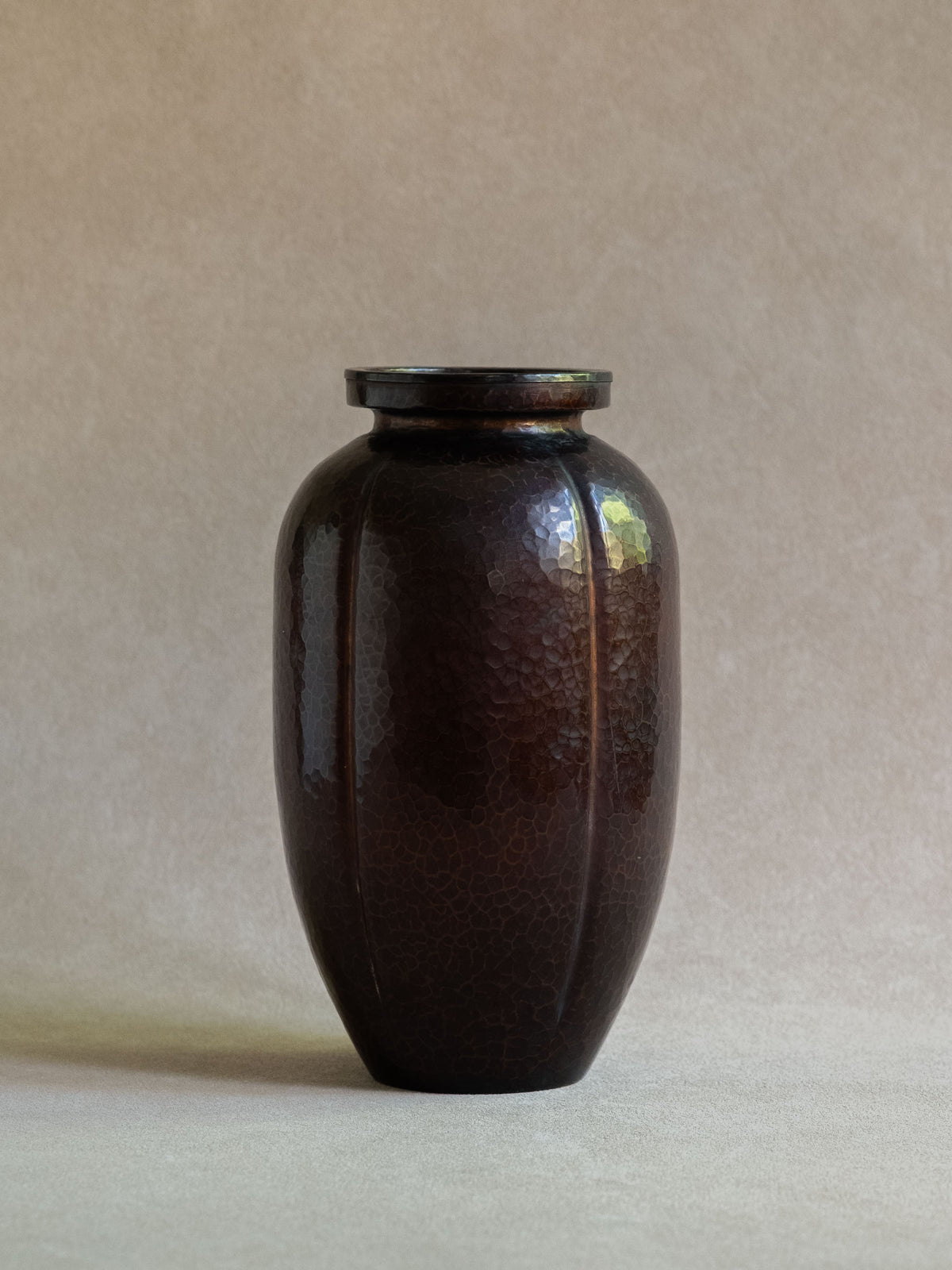 Full view of Japanese Dochu copper vase with compact ovoid body, raised rim, and dark hammered surface.
