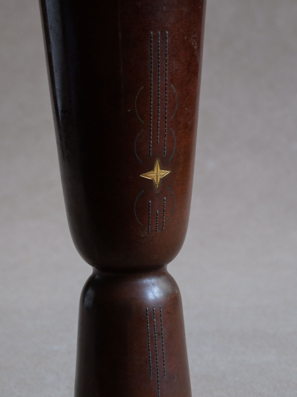 Detail of star and fine dotted zōgan metal inlay against the reddish-brown cast copper surface.