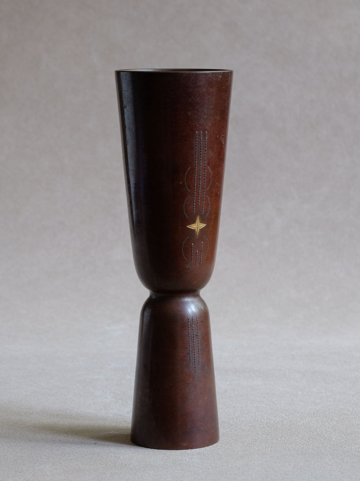 Full view of Japanese modernist cast copper vase showing slender geometric form and contrasting star inlay.