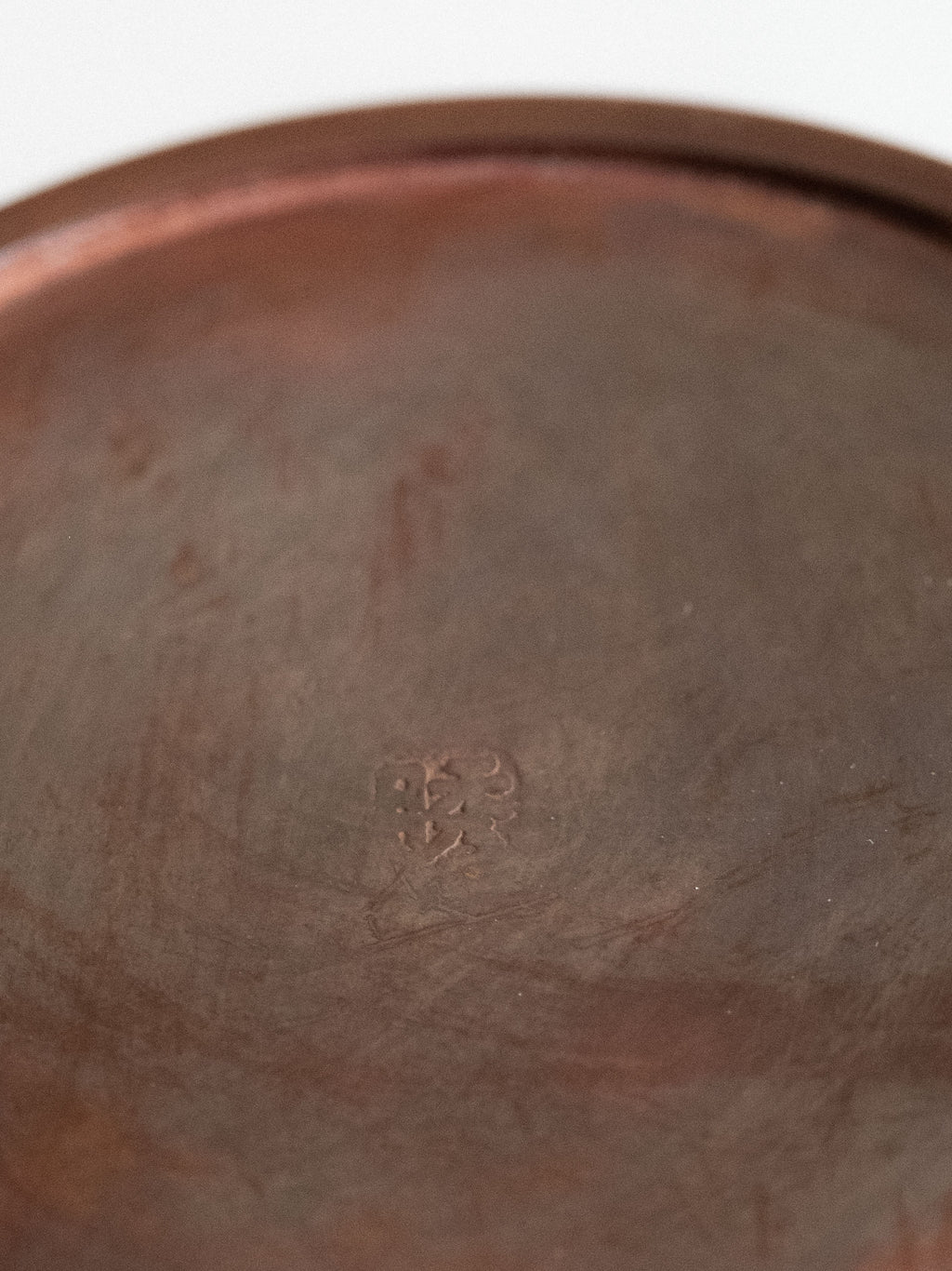 Close-up of the Shugetsu mark on the base of a Japanese Takaoka cast copper vase.

