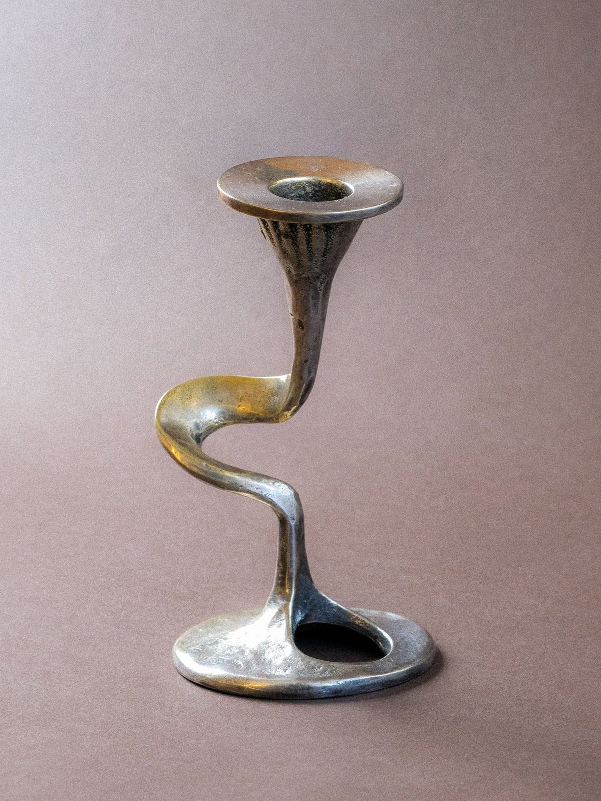 Kurt Jesch candleholder with silver-toned S-curve body, oval opening and age-related rubbing to the plated surface.